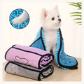 Petit chien blanc enveloppé dans la serviette en microfibre